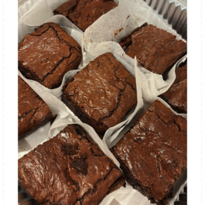 Freshly baked fudgy chocolate brownie, cut into 8 generous servings, rich and gooey in the center, served on a rustic plate — homemade with love by MumsFavouriteBakes