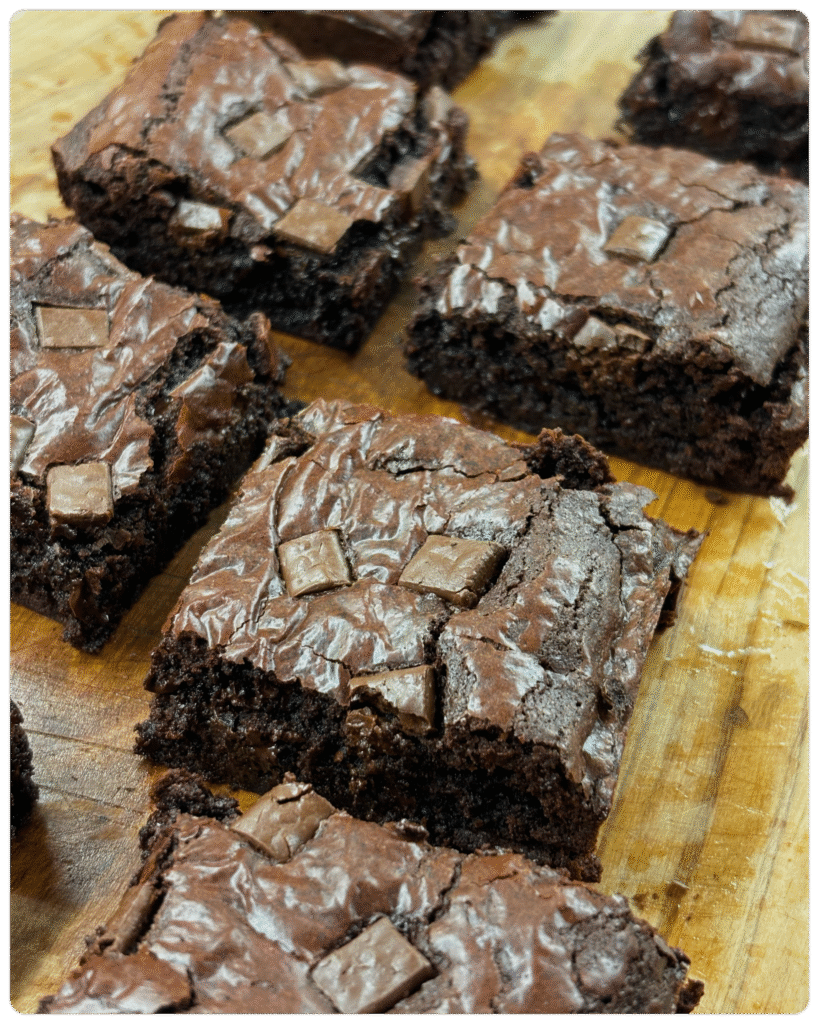 Freshly baked fudgy chocolate brownie, cut into 8 generous servings, rich and gooey in the center, served on a rustic plate — homemade with love by MumsFavouriteBakes